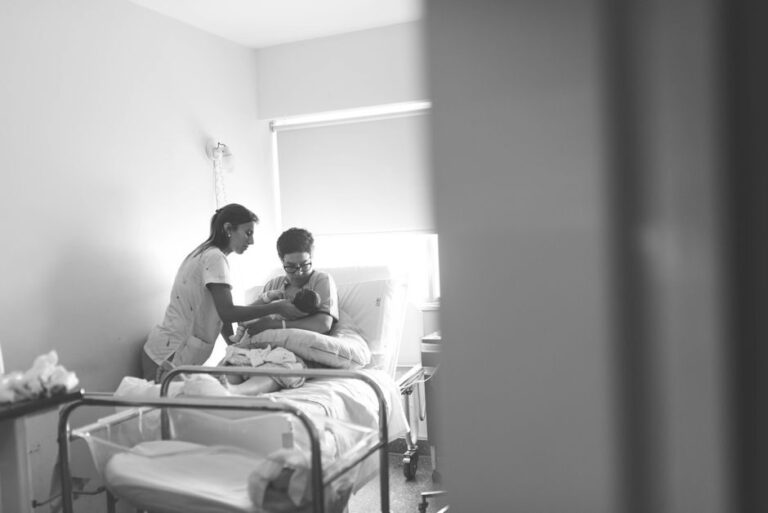 Profissional de saúde apoiando mãe na amamentação na maternidade